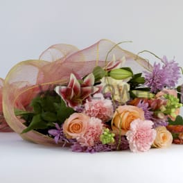 Bouquet of peach and pink flowers wrapped in pink mesh