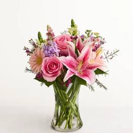 Pink roses and lilies in a clear glass vase