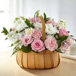 Pink and white flower arrangement in a woven basket