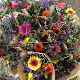 Bouquets of colorful gerbera daisies wrapped in brown paper