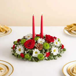 Red candles in a low floral centerpiece with white daisies and red roses