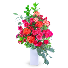 Tall bouquet of pink and orange roses in a white vase