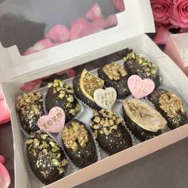 Box of chocolate-covered treats with pink heart decorations