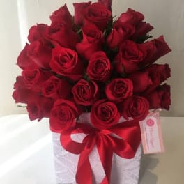 Bouquet of red roses in a white box with a red ribbon