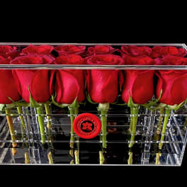 Red roses arranged in a clear rectangular acrylic box
