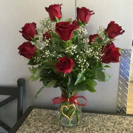 Bouquet of red roses in a glass vase with a red ribbon