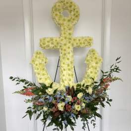 Anchor-shaped floral tribute on an easel with pastel flowers