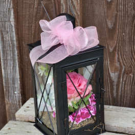 Black lantern with pink flowers and a pink bow
