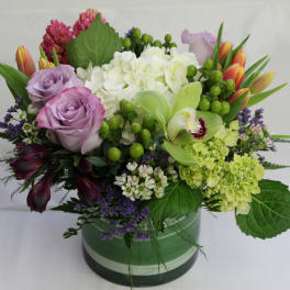 Mixed bouquet with lavender roses, white hydrangea, and green orchids in a vase
