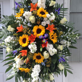 Large standing spray with sunflowers, lilies, and white roses