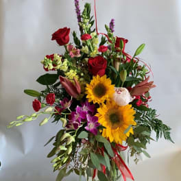 Mixed bouquet with red roses, sunflowers, lilies, and orchids