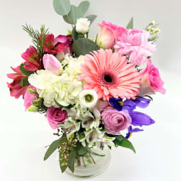 Mixed bouquet in a clear glass vase with pink and white blooms