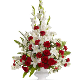 Red roses and white lilies in a white urn vase