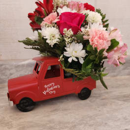 Mixed bouquet in a red truck-shaped container with a Valentine message