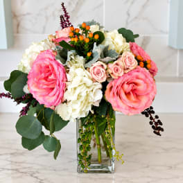 Pink roses and white hydrangeas in a clear glass vase