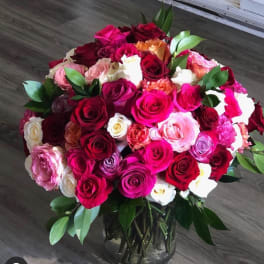 Large bouquet of multicolored roses in a glass vase