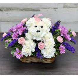 White floral teddy bear in a basket with pink and purple flowers
