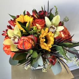 Bouquet with sunflowers, roses, and pale orchids in a vase