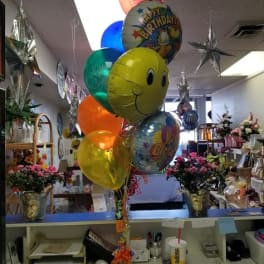 Birthday balloons in a flower shop with bouquets in the background