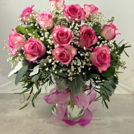 Pink roses arranged in a glass vase with baby's breath