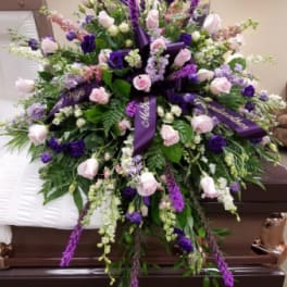 Large purple and pink funeral spray on a casket