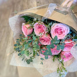 Bouquet of pink roses with eucalyptus in brown paper wrap