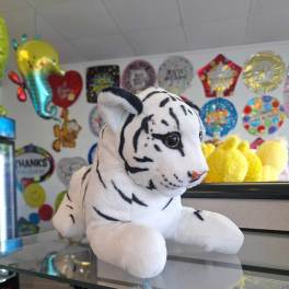 White plush tiger toy with black stripes on a counter