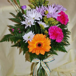 Mixed bouquet with gerbera daisies and carnations in a glass vase