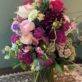 Mixed pink, white, and purple bouquet in a glass vase