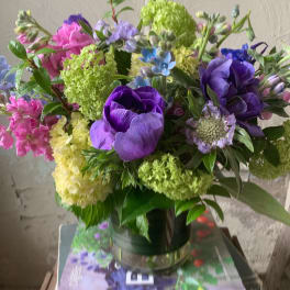 Bouquet of purple, pink, and green flowers in a glass vase