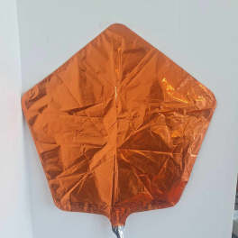 Orange metallic foil balloon shaped like a leaf or kite