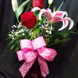 Bouquet of red roses and pink lilies with a pink bow