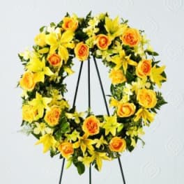 Yellow and orange floral wreath on a black stand