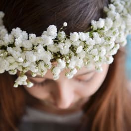 White baby’s breath flower crown worn on a girl’s head, viewed from above