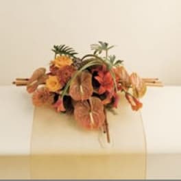 Tropical floral arrangement with orange and yellow blooms on a stand