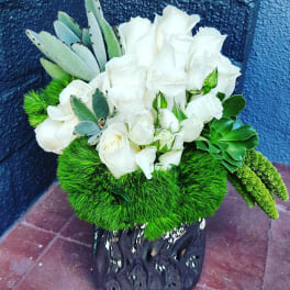 White rose bouquet with green succulents in a black vase