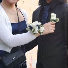 Couple wearing white rose corsage and boutonniere