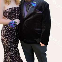 Formal couple wearing matching purple floral wrist corsages and boutonniere