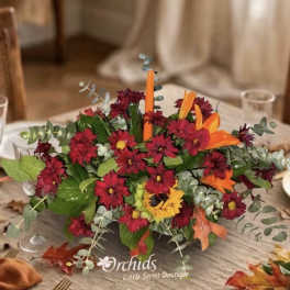 Low centerpiece with red and orange flowers in a rectangular container