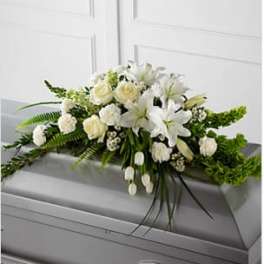 White floral casket spray with lilies and roses