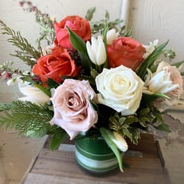 Mixed roses and white tulips in a green glass vase