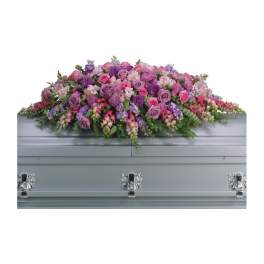 Pink and purple floral spray on a silver casket