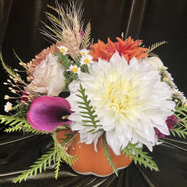 Mixed floral arrangement in an orange pumpkin-shaped container