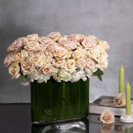 Blush roses and white hydrangeas in a green glass vase