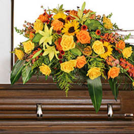Yellow and orange floral spray on a wooden casket