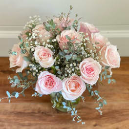 Pink roses and baby's breath in a glass vase