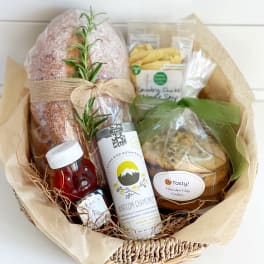 Gift basket with bread, tea, honey, and cookies