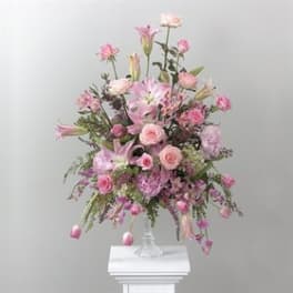 Tall pink floral arrangement in a clear glass vase