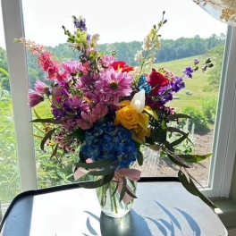 Mixed bouquet of colorful flowers in a clear glass vase