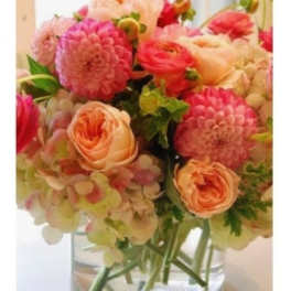 Pink and peach flowers arranged in a clear glass vase